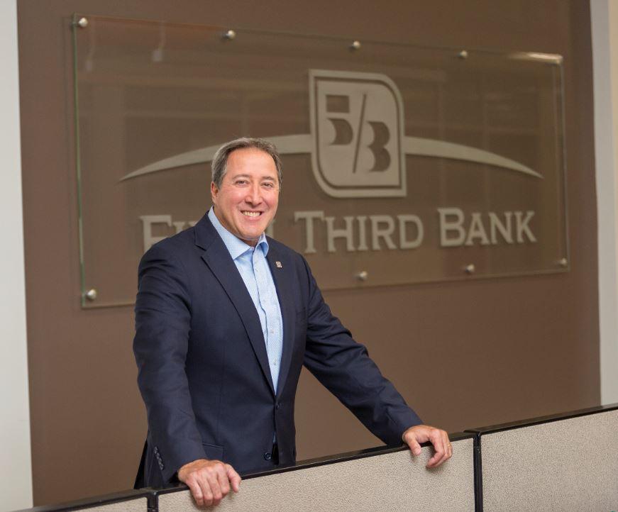 Photo of Greg Carmichael in front of Fifth Third Bank sign