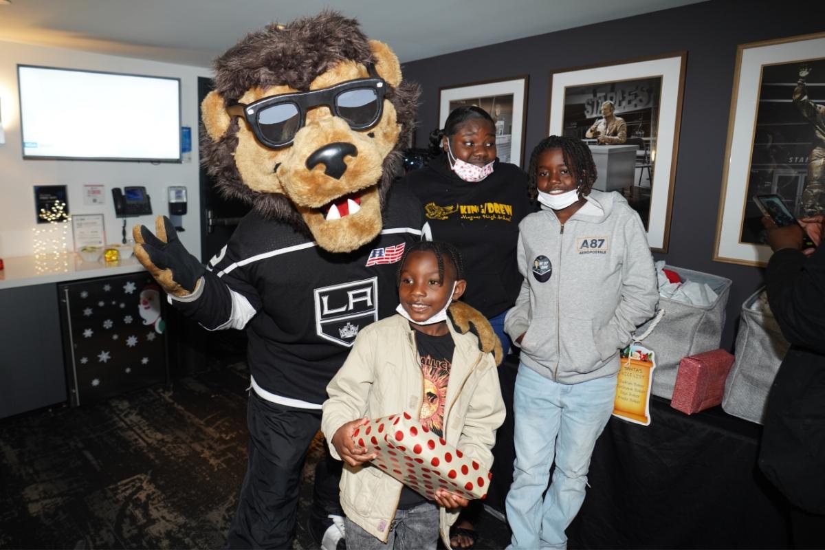 LA Kings mascot Bailey poses with families during the LA Kings Adopt-A-Family event at Crypto.com Arena (formerly STAPLES Center).