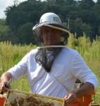 Photo of Ingro Desvousges; Delivery Systems Forester- PSEG; wearing beekeepers hat and gloves.