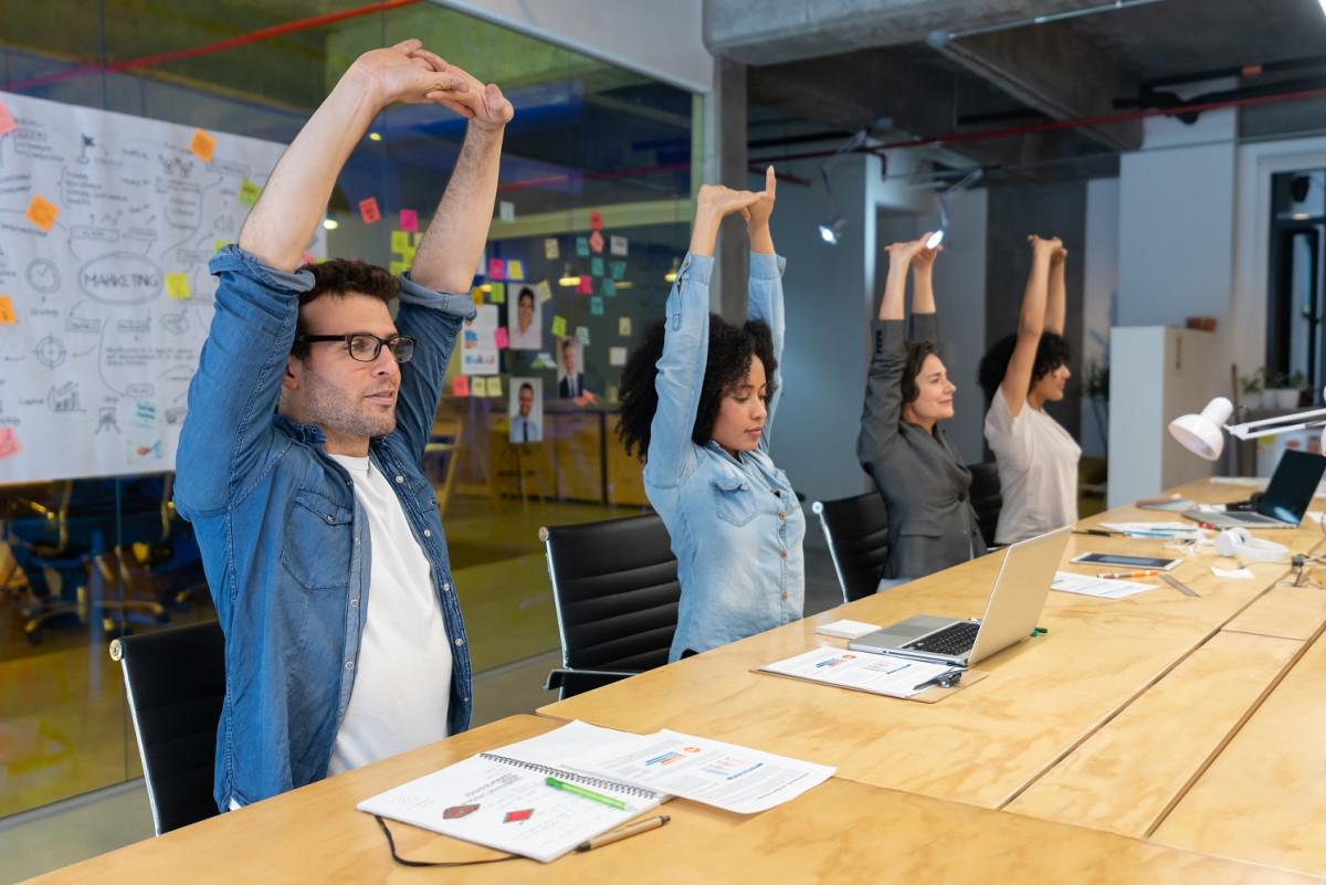 people at conference table stretching