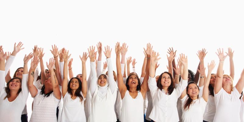 group of people all wearing white shirts, arms raised up