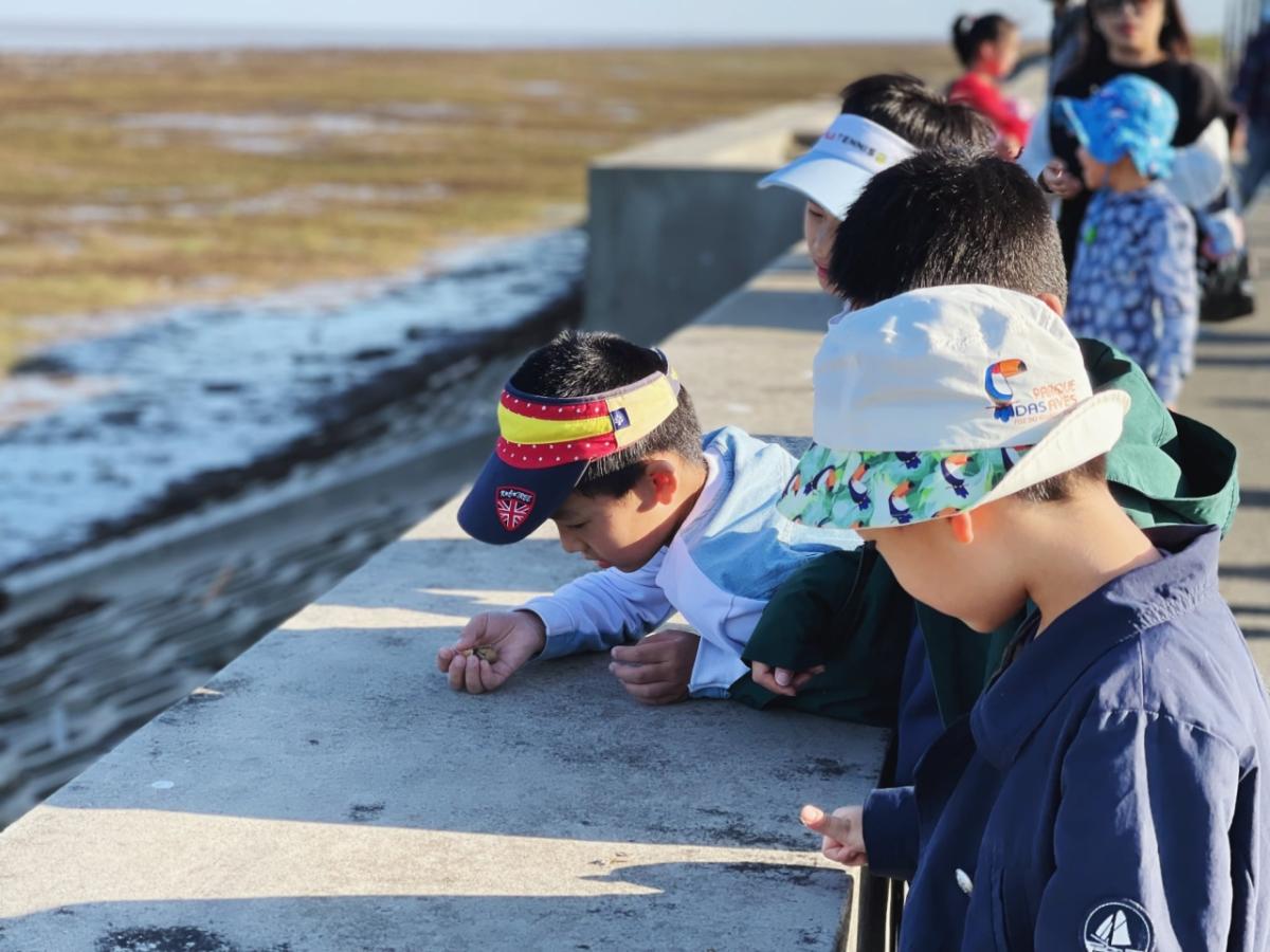 Children in China looking at ocean by a sea wall.