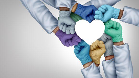 group of gloved hands together forming a heart