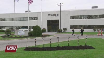 outside wide view of Whirlpool office building. Eight shovels standing up in a pile of dirt in front.